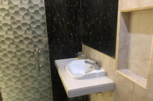 La salle de bains est pourvue d'un lavabo et d'une douche. dans l'établissement TwoSpaces Living at D'Rainbow Homestay, à Mergoredjo