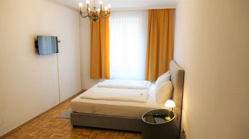 a small bedroom with a bed and a window at Hotel Kindler 2,0 Self-Check-In in Leoben