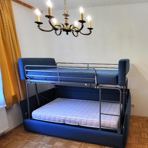 a bunk bed in a room with a chandelier at Hotel Kindler 2,0 Self-Check-In in Leoben