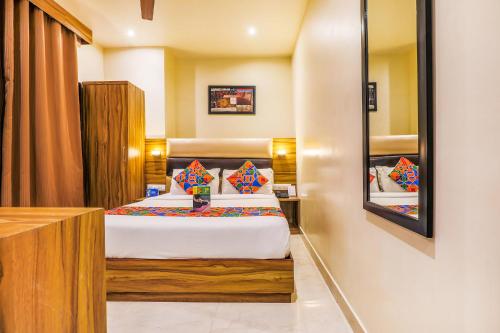 a hotel room with a bed and a mirror at FabHotel Liwa International in Mumbai