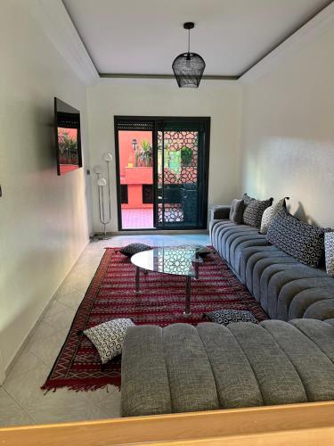 uma sala de estar com um sofá e uma mesa em APPARTEMENTS NIA CONFORT, Plein centre ville, avec TERRASSE em Fez