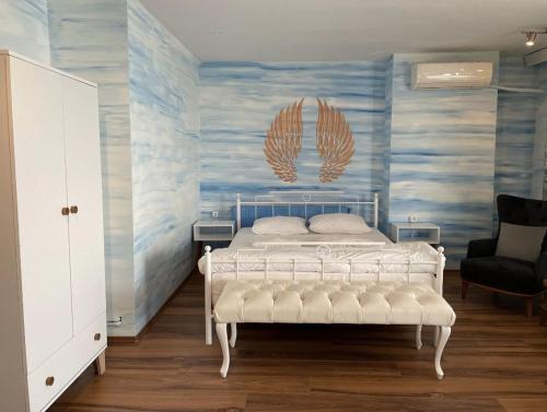 a bedroom with a white bed and a blue wall at Poyraz Resort in Marmaraereglisi