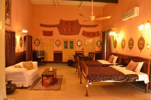 uma sala de estar com duas camas e um sofá em Bhairon villas em Bikaner