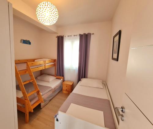 mały pokój z 2 łóżkami i drabiną w obiekcie Apartment in Murter w mieście Murter