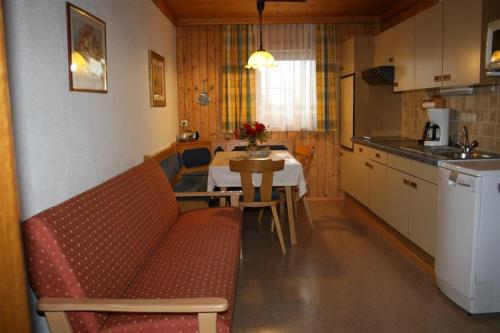 a living room with a kitchen and a table with a couch at Ferienwohnungen Foidlhof in Hochfilzen