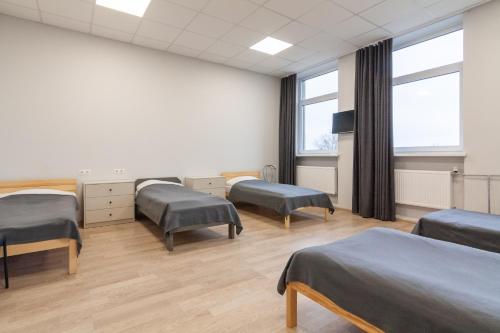 a hospital room with three beds and windows at BAZZE in Klaipėda
