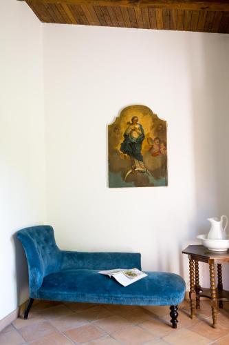 a blue couch in a room with a painting on the wall at Agriturismo La Pesca in Broccostella