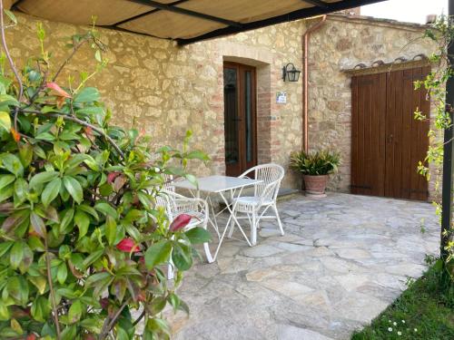 a patio with chairs and a table and a door at Podere La Paolina in Montefollonico