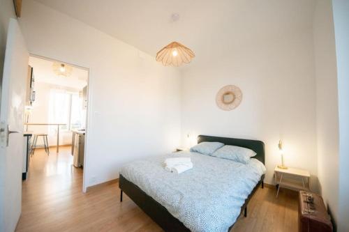 une chambre avec un lit et un lustre dans l'établissement Superbe appartement 2 pièces avec vue mer - Brest, à Brest