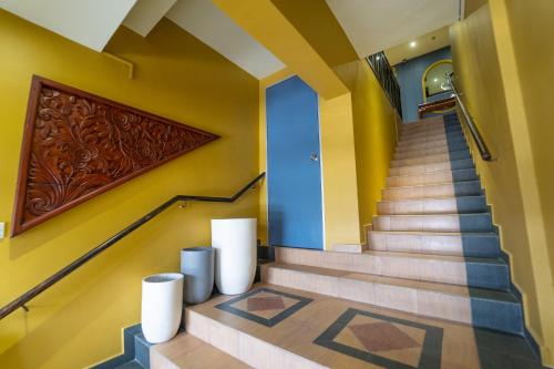 a staircase in a house with yellow and blue walls at The Colony by Cactus Hotel Dedap in Johor Bahru