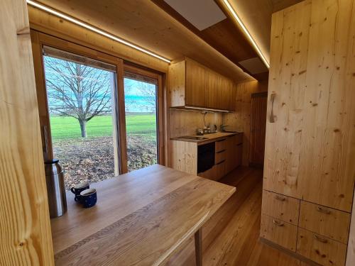eine Küche mit einem großen Fenster in einer Holzhütte in der Unterkunft Villa Larix-Das Vollholzhaus direkt am Berzdorfer See in Görlitz
