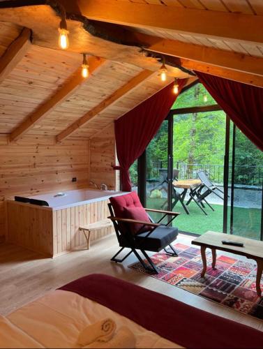 a room with a bench and a chair in a cabin at Esinti Bungalows Otel in Çamlıhemşin