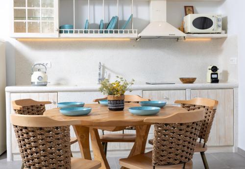 a kitchen with a wooden table with blue bowls on it at Casa di Mare Luxury Villas in Imerovigli