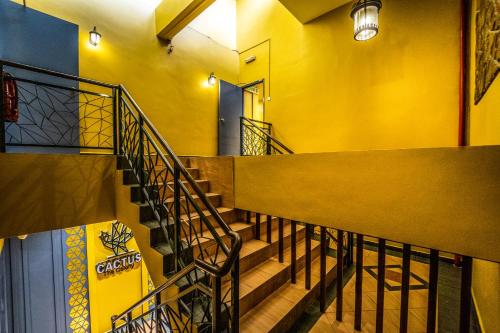 a staircase in a building with a yellow wall at The Colony by Cactus Hotel Dedap in Johor Bahru
