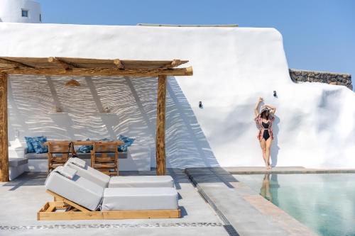 a woman jumping into the water from a swimming pool at Casa di Mare Luxury Villas in Imerovigli