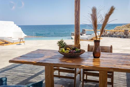a wooden table with a bowl of fruit on it at Casa di Mare Luxury Villas in Imerovigli