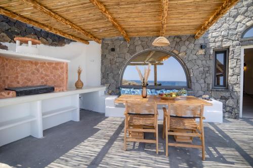 a kitchen and dining room with a table and chairs at Casa di Mare Luxury Villas in Imerovigli