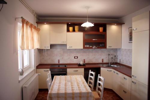 una cucina con mobili bianchi e un tavolo con sedie di Apartments Nada a Pag