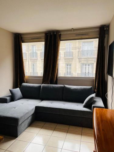 un salon avec un canapé et deux fenêtres dans l'établissement Studio Paradis, à Marseille