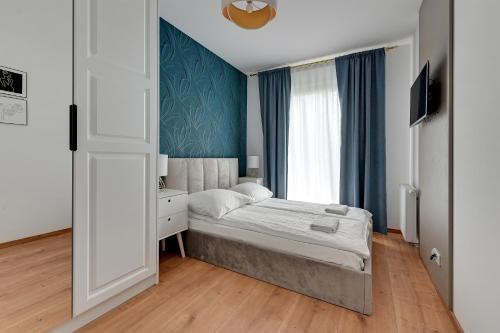 a small bedroom with a bed and a window at Apartment Porto near the sea in Gdansk in Gdańsk