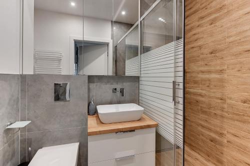 a bathroom with a sink and a mirror at Apartment Porto near the sea in Gdansk in Gdańsk