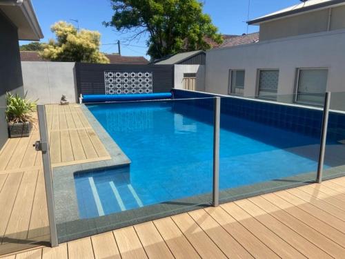 a swimming pool in front of a house at THE DECK HOUSE - Beautiful Busselton Beachfront in Busselton