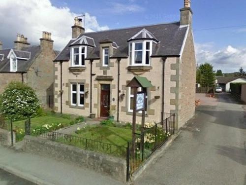 a large house with a fence in front of it at Heathcote B&B in Inverness