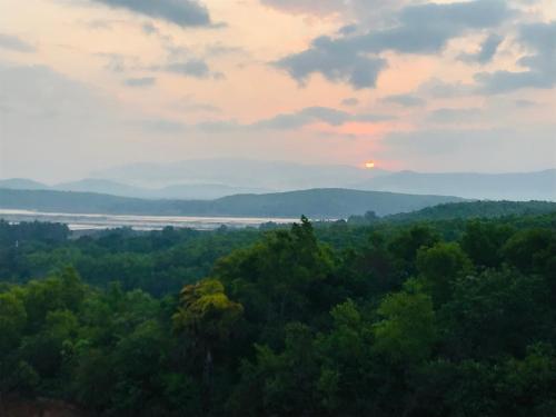 a view of the sunset from a hill with trees at Hotel Golden Heights Gokarna in Gokarna