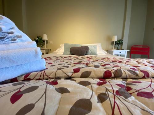 a bed with a colorful blanket on top of it at Refitolería Apartamentos in Segovia