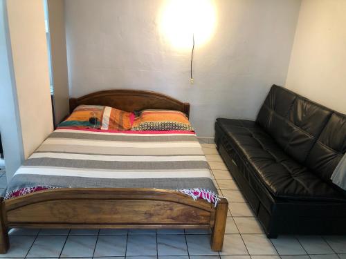 a bed and a couch in a room at à pied dans l eau écolo 97434 in L'Ermitage-Les-Bains
