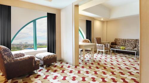 a waiting room with chairs and a desk and a window at Berjaya Waterfront Hotel, Johor Bahru in Johor Bahru