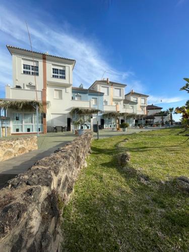 a row of houses next to a stone wall at ON Family Playa de Doñana in Matalascañas