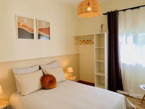 Schlafzimmer mit einem weißen Bett und einem großen Fenster in der Unterkunft Gîte Clair de Lune in Monts-sur-Guesnes