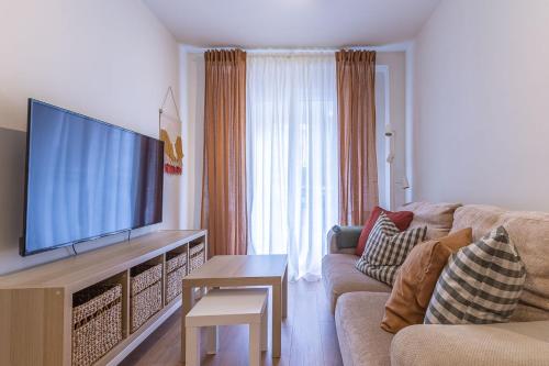 a living room with a couch and a large flat screen tv at Apartamento. El Rincón de Cañadío in Santander