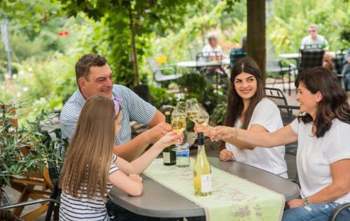 a group of people sitting at a table with wine glasses at Weingut Erich Serwazi in Mesenich