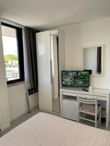 a room with a desk with a television and a window at Euro Meublé in Grado