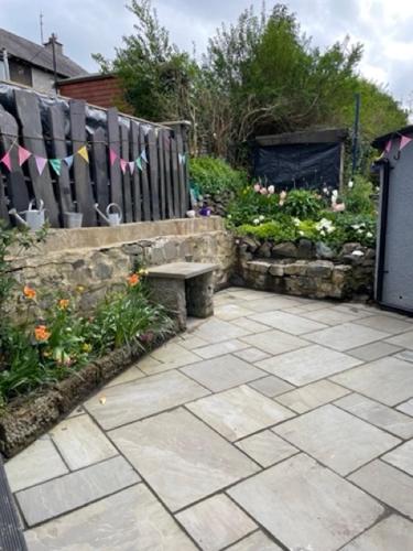 a garden with a bench and a fence and flowers at Penchwintan in Bangor