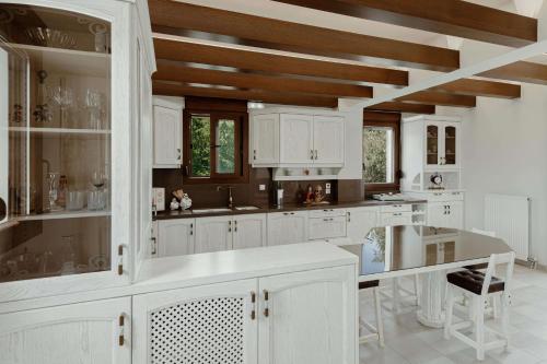 ゲラニにあるEmmaの白いキャビネットと木製の天井が備わるキッチン