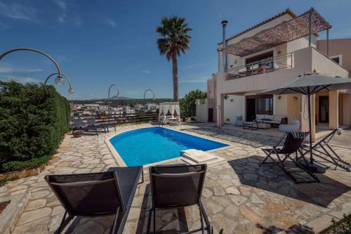 a villa with a swimming pool in front of a house at Villa Emma in Gerani