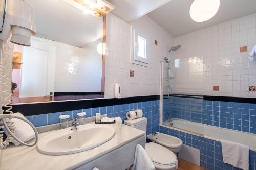 a bathroom with a sink and a toilet and a tub at ON Family Playa de Doñana in Matalascañas