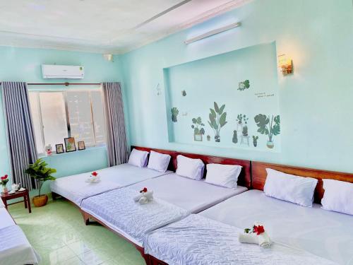 two beds in a room with blue walls at THANH THẢO MOTEL in Vung Tau