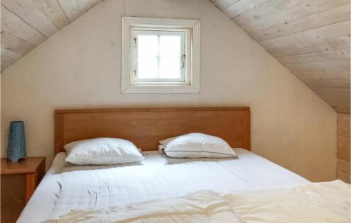1 dormitorio con 1 cama con 2 almohadas y ventana en 2 Bedroom Amazing Home In Grdd, en Gräddö