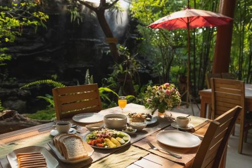 來興的住宿－Vanasin Residence，一张带食物的木桌和雨伞
