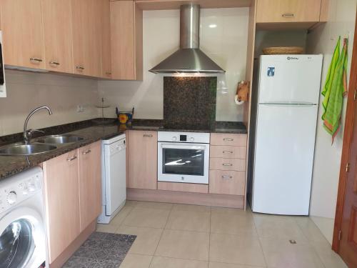 une cuisine avec un réfrigérateur blanc et un évier dans l'établissement CAN PLANAS Soleado, amplio con vistas y parking, à Sant Joan de les Abadesses