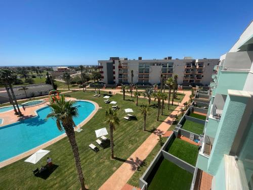 uma vista aérea de um resort com uma piscina e palmeiras em Apartamentos Moon Dreams Almerimar em Almerimar