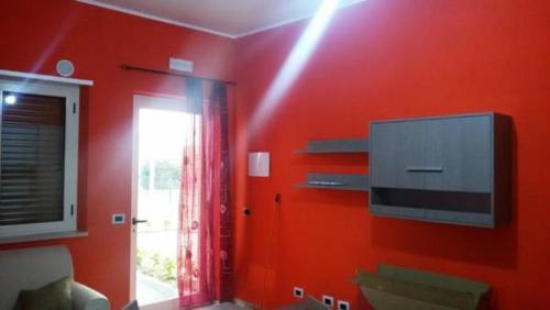 a red room with a tv and a red wall at B & B Residence L'Ancora in Villapiana