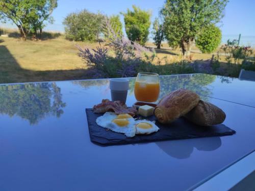 a plate of eggs and bread and a glass of orange juice at Gîte avec piscine au cœur de la campagne 