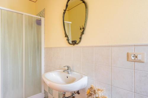 łazienka z umywalką i lustrem na ścianie w obiekcie Calla w mieście Montecarlo