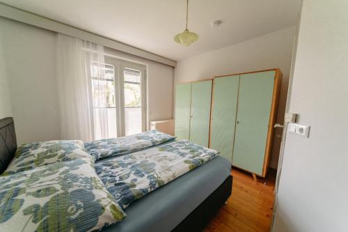 1 dormitorio con cama y ventana en Apartments Obir am Wörthersee, en Krumpendorf am Wörthersee