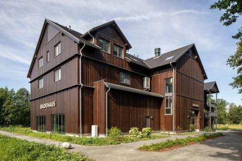 a large wooden building with a gambrel roof at Landhotel Burg im Spreewald - Resort & Spa in Burg